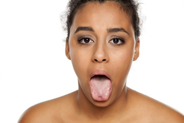 poprtrait of young dark-skinned woman with her tongue out on white background