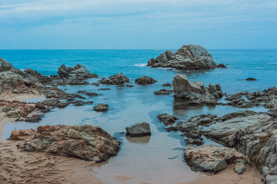 Calm clear sea and stones in water, Spain, image taken with long exposure