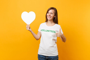 Portrait of smiling woman in white t-shirt with written inscription green title volunteer hold...
