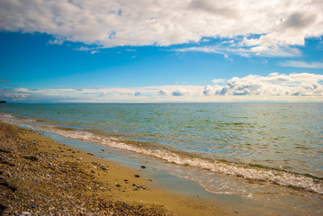 The sea shore, with blue sky and clouds and clear sea