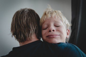 father comforting stressed crying sad son, parenting