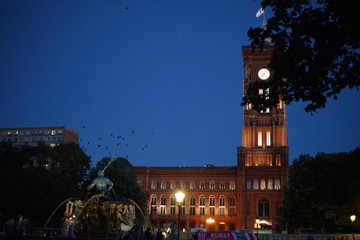 Fototapeta premium The red city hall (Rotes Rathaus) with the Neptune Fountain ( Neptunbrunnen) , Alexanderplatz in Berlin