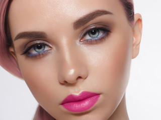 Close-up of woman's lips with fashion bright pink make-up. Beautiful female mouth, full lips with perfect makeup. Part of female face. Choice lipstick. Pink wavy hair of a Barbie doll