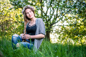 Obraz premium Natural beautiful girl in the garden on spring grass. Young candid woman, beauty and fashion, outdoors