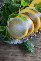 Lemon slices with sugar and mint leaves.