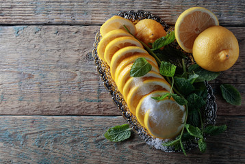 Lemon slices with sugar and mint leaves.
