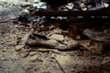 Zurückgelassener, kaputter Schuh im Dreck