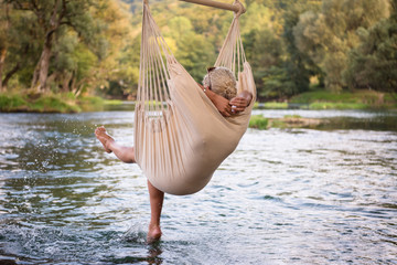 blonde woman resting on hammock