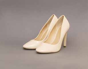 Beige high heel shoes on grey