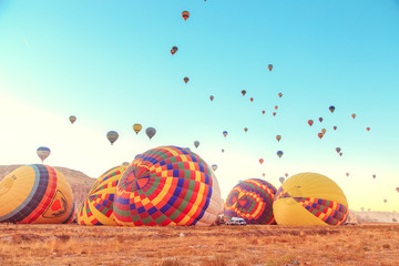 Naklejka premium Preparing hot air balloons to flyght. Dawn in Cappadocia.