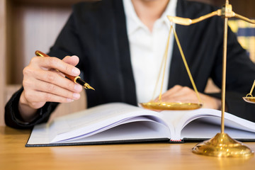 lawyer judge reading documents at desk in courtroom working on wooden desk background. gavel  golden Weight. and soundblock of justice.