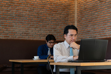 Asian businessman stress at work. working with laptop in a cafe. business concept.