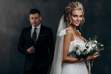 beautiful sexy blonde bride posing in wedding dress with her husband