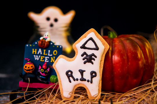Fresh homemade decorated halloween cookies and sweets on dark background, concept of halloween monster party, copy space, close up