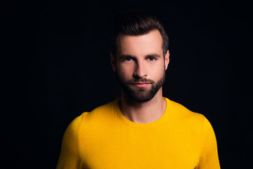 Fototapeta premium Portrait of confidence. Portrait of handsome young man looking at camera while standing against black background