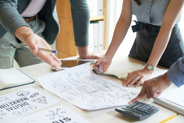 Business people standing and discussing business graphs at the table