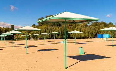 Beach umbrellas and deserted sandy beach in the early morning