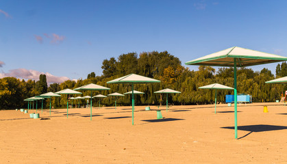 Beach umbrellas and deserted sandy beach in the early morning