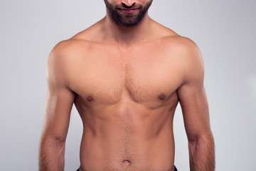Perfection. Part of handsome shirtless young man standing against white background