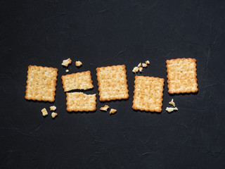 French cracker with sesame seeds on a black background. Flat lay, top view, copy space