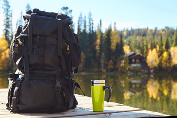 backpack on the pier by the lake in the mountains.