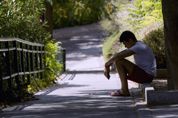 Lonely teenager sitting on the street