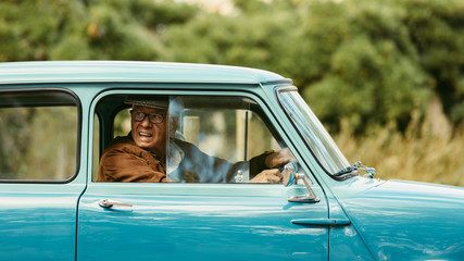 Old man driving a classic car