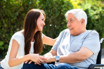 Obraz premium Woman Looking At Her Father Sitting On Wheelchair