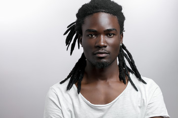 African American male with dreadlocks on white background looking at camera