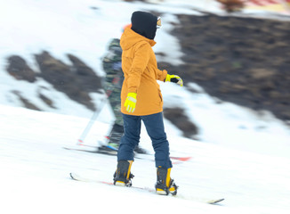 Girl snowboarding from the mountain in winter