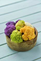 cauliflower of different colors in a boxwood bowl