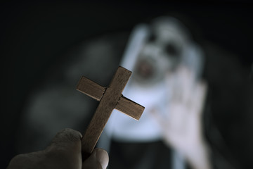 frightening evil nun screaming in front of a cross