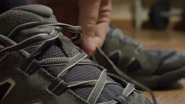 Closeup tying shoelaces on sneakers. Athlete tied up shoelaces, running shoes. Close up. Slow motion.