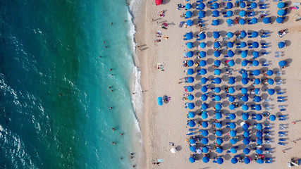 Aerial top view photo of sun beds in popular tropical paradise deep turquoise sandy beach of Kathisma, Lefkada island, Ionian, Greece