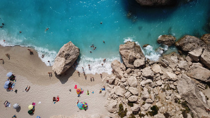 Aerial top view photo of sun beds in popular tropical paradise deep turquoise sandy beach of Kathisma, Lefkada island, Ionian, Greece