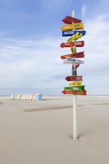 Sign post with world destinations at the beach of Berck-Plage, France