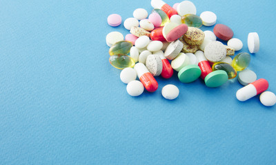 Pills are scattered over a blue background