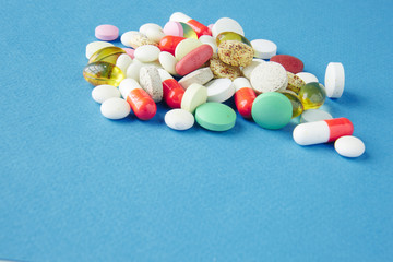 Pills are scattered over a blue background