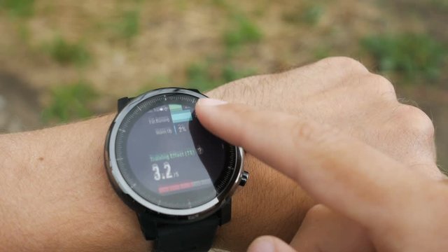 Results of a running training session on smart watch. Smartwatch. Hand with sports watch which shows results of training. Pulse, speed, distance, calories
