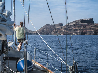 woman  on board of a sailing yacht, approaching Madeira, Portugal from sea 