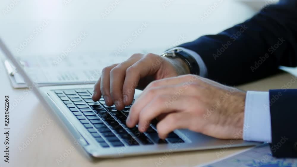 Poster Close up hands of unrecognizable businessman using laptop computer for work when sitting at desk, tracking shot