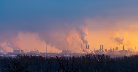 Smoke from the factory pipes against the dawn of the sun