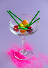 Colorful, sweet pastel lollipops in the glass on violet background