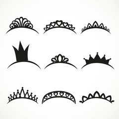 Set of black silhouettes of tiaras of various shapes on a white background © Azuzl