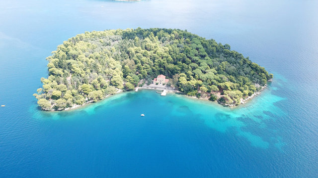 Aerial drone photo of iconic uninhabited island of Madouri in bay of Nydri and Mansion of 19th-century poet Aristotelis Valaoritis, Lefkada, Ionian, Greece