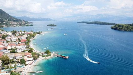 Obraz premium Aerial drone bird's eye view photo of iconic port of Nidri or Nydri a safe harbor for sail boats and famous for trips to Meganisi, Skorpios and other Ionian islands, Leflkada island, Ionian, Greece