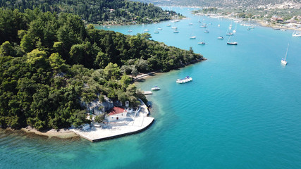 Obraz premium Aerial drone bird's eye view photo of iconic port of Nidri or Nydri a safe harbor for sail boats and famous for trips to Meganisi, Skorpios and other Ionian islands, Leflkada island, Ionian, Greece