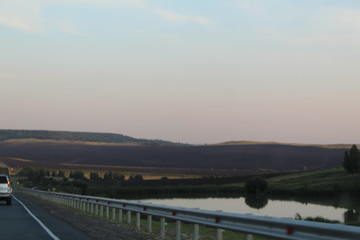 Smooth road. The landscape of the area. Travelling by car. Large margins to the horizon line