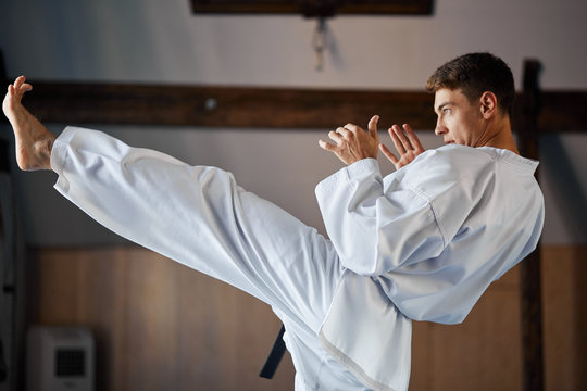 Karate. Man In Kimono Doing High Kick With His Foot