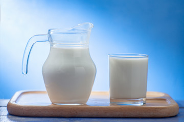 Splash of milk from the milk glass ,Morning milk, Glass jug and glass with milk on a wooden table on white background